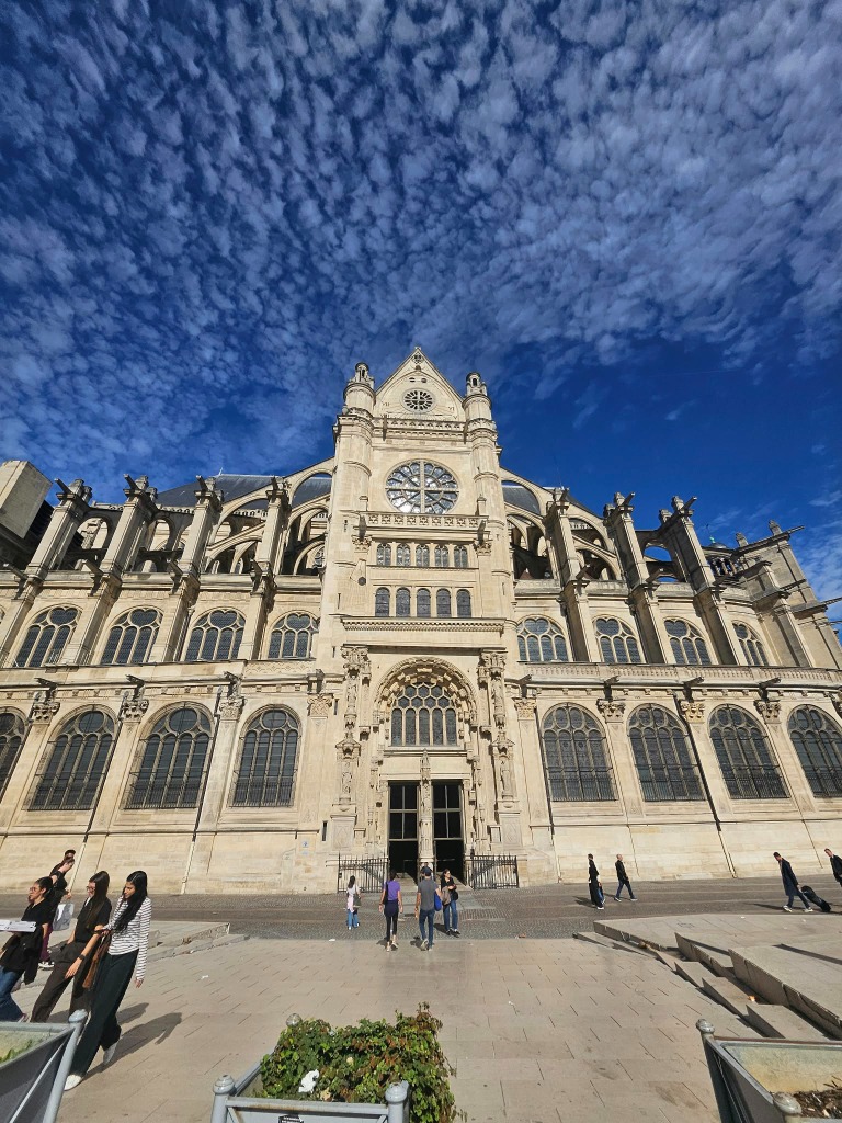 Soaring facade of Eglise Saint-Eustache under altocumulus clouds